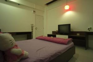 a bedroom with a teddy bear sitting on a bed at Sukontha Mansion in Ban Khlong Naraphirom