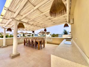 a patio with a table and chairs on a balcony at Villa Gladys in Watamu