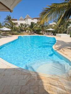a swimming pool with blue water in a resort at Villa Gladys in Watamu