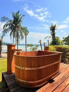 a wooden tub sitting on a deck near the beach at Tolani Resort Koh Kood in Ko Kood