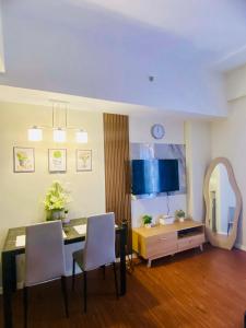 a dining room with a table and chairs and a mirror at Lolit cozy condo in Lapu Lapu City