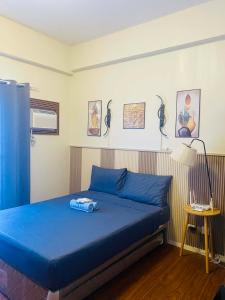 a bedroom with a blue bed and a lamp at Lolit cozy condo in Lapu Lapu City +4 photos