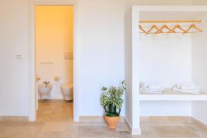 a bathroom with a toilet and a vase of flowers at Masseria il Vignale in Ostuni