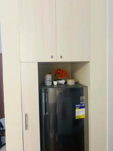 a black refrigerator in a kitchen with white cabinets at Lolit cozy condo in Lapu Lapu City
