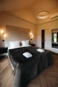 a bedroom with a large bed with two towels on it at De Zeeuwse Tuinkamers in Kapelle +10 photos