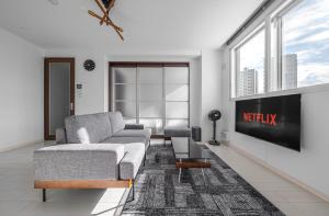 a living room with a couch and a tv at Grandia 302 in Sapporo