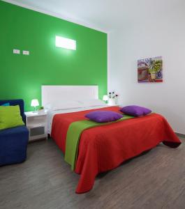 a bedroom with a bed with a green wall at Arricàmpati Airport Rooms & Bringo Car Rental in Carini