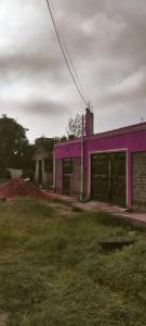 a pink building with a grass yard in front of it at Yua Residence in Machakos