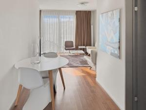 a living room with a white table and chairs at Comfortable 1BR flat at great location - Baron 44 in Zurich