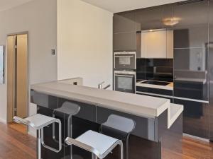 a kitchen with a counter and stools in it at Comfortable 1BR flat at great location - Baron 44 in Zurich