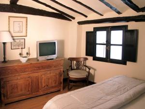 a bedroom with a bed and a television on a dresser at Casa Rural Las Pedrolas in Arnedillo