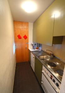 a small kitchen with a sink and a stove at Antares 006 au centre a Anzere in Anzère