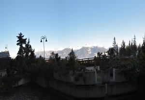 a view of mountains from a garden with trees at Antares 006 au centre a Anzere in Anzère