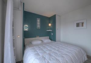 a bedroom with a white bed with a green wall at Antares 402 au centre a Anzere in Anzère +3 photos