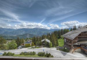 a view of a building with mountains in the background at Antares 403 au centre a Anzere in Anzère