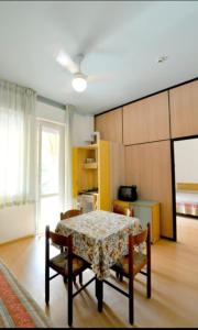 a room with a table and chairs and a kitchen at Hotel Residence Villa Lily in Cesenatico