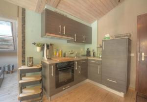 a kitchen with stainless steel appliances and wooden cabinets at Antares 507, au centre a Anzere in Anzère