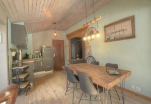 a kitchen and dining room with a wooden table and chairs at Antares 507, au centre a Anzere in Anzère