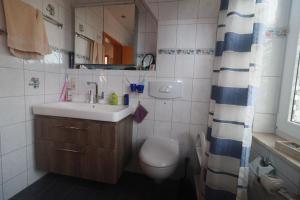 ein Badezimmer mit Waschbecken, Toilette und Duschvorhang in der Unterkunft FW Lehmann in Zingst + 15 Fotos