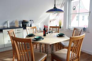 eine Küche mit einem Holztisch und Stühlen sowie ein Esszimmer in der Unterkunft FW Lehmann in Zingst