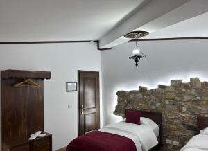 a bedroom with two beds and a stone wall at Hotel Berati in Berat
