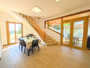 a dining room with a table and chairs and a staircase at VILLA SEA VIEW IN SICILY, Real Relax in Fontane Bianche