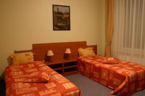 a bedroom with two beds and a table with lamps at Motel Paradise in Vilnius