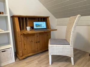 a laptop computer sitting on a wooden desk with a chair at Altrhein Hideaway ruhige Ferienwohnung nahe Frankfurt ideal für Natur & Radfahrer in Riedstadt