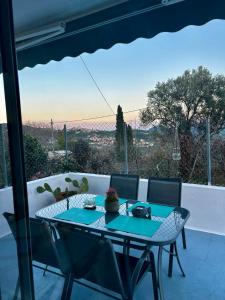 a table and chairs on a patio with a view at Petrino Minimal in Dhéndra