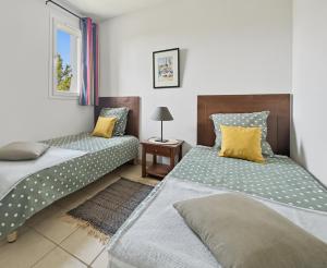 two beds in a small room with a table at T3 Piscine Classé 3, Park, Terrasse in Prayssac +26 photos