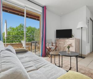 a living room with a couch and a tv at T3 Piscine Classé 3, Park, Terrasse in Prayssac