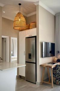 a kitchen with a stainless steel refrigerator and a table at Palm Springs in Struisbaai
