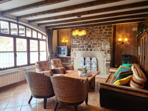 a living room with a table and a stone fireplace at Oceano verde in Cervera de Pisuerga