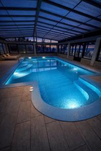 a large swimming pool with blue water in a building at Villas Verde Dalmatia in Jesenice +51 photos