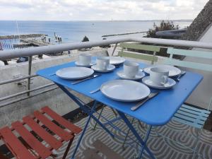 a blue table with cups and saucers on a balcony at Hafenblick in Kiel