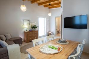 a living room with a wooden table and a tv at Villa Avlaki in Vlikhón