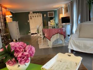 a living room with a vase of pink flowers on a table at Gîte EMOZIONE in Guebwiller