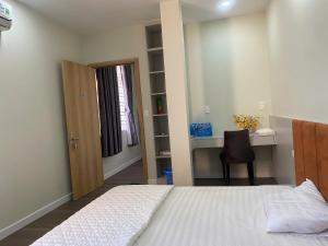 a bedroom with a bed and a door and a desk at Love's Hotel in Nhơn Trạch