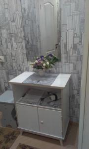 un jarrón de flores sentado encima de un tocador en Apartment Horkoho 7A en Shostka