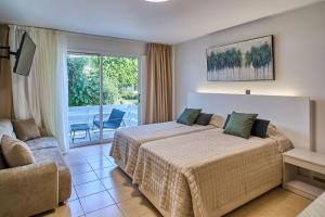 a hotel room with two beds and a balcony at Marianna Hotel Apartments in Limassol