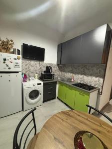 a kitchen with green and white appliances and a table at Studio in the center in Craiova
