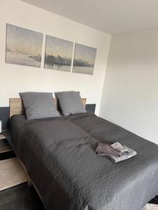 a bed in a bedroom with four pictures on the wall at Comfort Rooms mit Whirlpoolzugang in Romanshorn