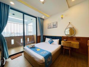 a bedroom with a bed and a mirror and a window at Sea Night - Sea Home Hotel in Phan Thiet
