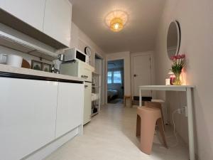 a kitchen with white cabinets and a table with a vase of flowers at Hill-house in Samgong +23 photos