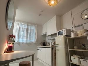 a small kitchen with a refrigerator and a table at Hill-house in Samgong