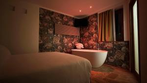a bedroom with a bed and a tub and a window at Corte d'Arnosto - Casa Virginia in Fuipiano Valle Imagna