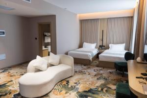 a hotel room with two beds and a couch at Green gobi hotel in Dalandzadgad