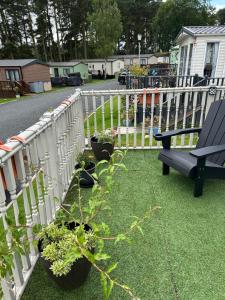 a fence with potted plants and a bench on a yard at 26 Golf View in Jedburgh