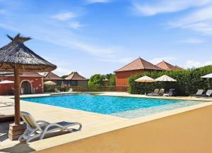 a swimming pool with chairs and umbrellas at T3 Piscine Classé 3, Park, Terrasse in Prayssac