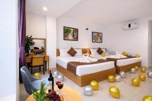 a hotel room with two beds and a table with wine glasses at khách sạn Aloha in Hanoi +19 photos